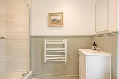 a bathroom with a sink and a towel ladder at Millicent Cottage, Aldeburgh in Aldeburgh