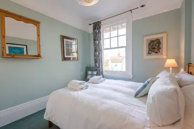 a bedroom with a large white bed with a window at Kingsfield House, Aldeburgh in Aldeburgh