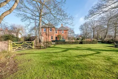a large brick house with a fence in a yard at Kingsfield House, Aldeburgh in Aldeburgh