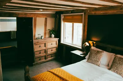 a bedroom with a bed and a window and a dresser at The George in Cavendish