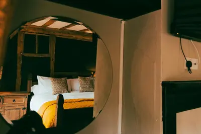 a bedroom with a bed in a room with a mirror at The George in Cavendish