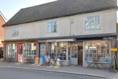 a person sitting in the front of a building at Host My Nest - Historic 1BR 20 Mins to Stansted in Sawbridgeworth