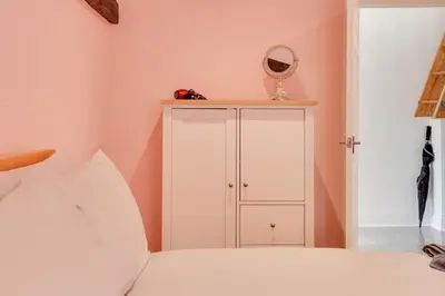 a bedroom with a white cabinet and a mirror at Host My Nest - Historic 1BR 20 Mins to Stansted in Sawbridgeworth
