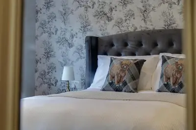 a bedroom with a bed with white sheets and pillows at The Kings Arms Rooms in Saint Osyth