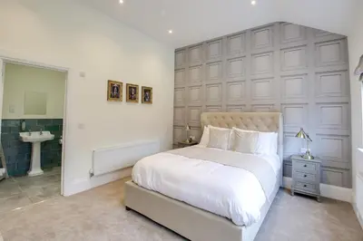 a bedroom with a large white bed and a sink at The Kings Arms Rooms in Saint Osyth