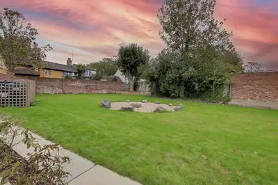 a garden with a fire pit in the grass at The Kings Arms Rooms in Saint Osyth