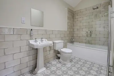 a bathroom with a sink and a toilet and a tub at The Kings Arms Rooms in Saint Osyth