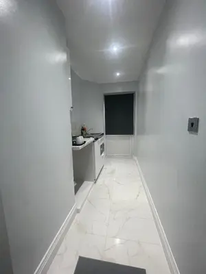 a white hallway with a sink and a kitchen at Cozy Studio Flat Romford, London in Romford