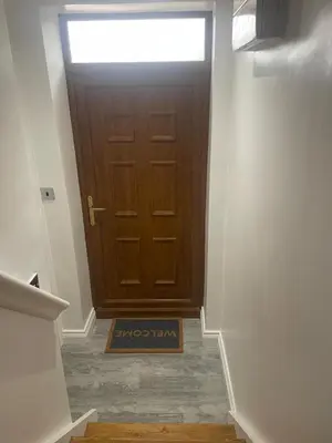 a hallway with a door with a sign in front at Cozy Studio Flat Romford, London in Romford