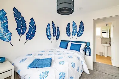 a bedroom with blue and white feathers on the wall at Comfortable 4-Bedroom Heaven in Thetford in Thetford