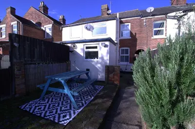 a blue picnic table in front of a house at Stylish & Cosy Stay 2-Bed House Train Station Hospital Garden Fast WiFi in Colchester