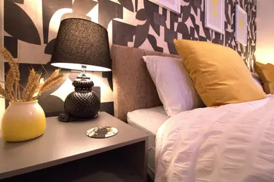 a bedroom with a bed and a table with a lamp at Stylish & Cosy Stay 2-Bed House Train Station Hospital Garden Fast WiFi in Colchester