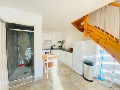 a kitchen with a staircase and a table and refrigerator at The Mews Flats - Cambridge, Central Location CB1 in Cambridge