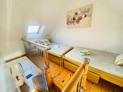 a small room with two beds and a staircase at The Mews Flats - Cambridge, Central Location CB1 in Cambridge