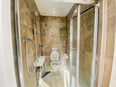 a bathroom with a toilet and a glass shower at The Mews Flats - Cambridge, Central Location CB1 in Cambridge