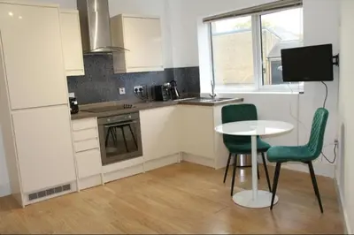 a kitchen with a table and two chairs and a table at No 13 Colchester Town Flat with Kitchen & Parking in Colchester
