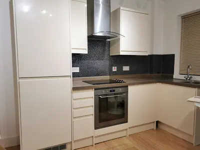 a kitchen with white cabinets and a stove at No 13 Colchester Town Flat with Kitchen & Parking in Colchester