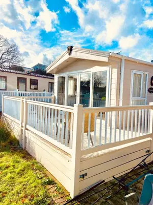 a porch on a house with a white railing at Lakeside mini lodge in Saint Osyth