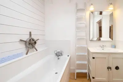 a bathroom with a bath tub and a sink at 3 Uplands, Thorpeness - Sleeps 3, Close to Beach, Boating Lake, Thorpeness Golf Club and Country Club - Aldeburgh Coastal Cottages in Thorpeness