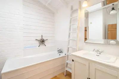 a bathroom with a sink and a tub and a mirror at 3 Uplands, Thorpeness - Sleeps 3, Close to Beach, Boating Lake, Thorpeness Golf Club and Country Club - Aldeburgh Coastal Cottages in Thorpeness