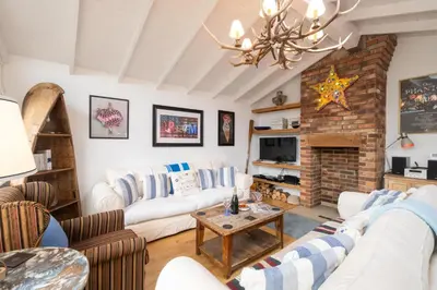 a living room with white furniture and a brick fireplace at 3 Uplands, Thorpeness - Sleeps 3, Close to Beach, Boating Lake, Thorpeness Golf Club and Country Club - Aldeburgh Coastal Cottages in Thorpeness