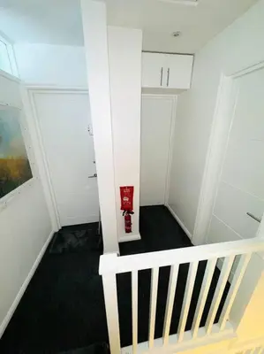 a stairway with a red fire hydrant in a room at Three bedroom house in Harlow