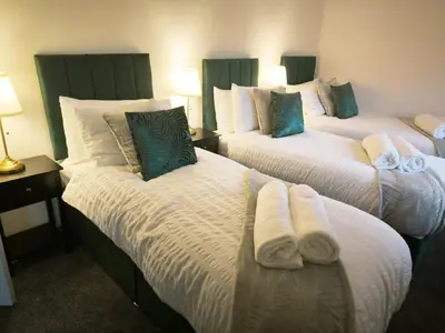 a hotel room with two beds with towels on them at Comfortable 2-Bed Home, Perfect for Work and Leisure in Colchester in Colchester