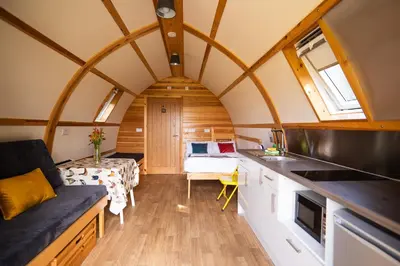 a kitchen and living room in a tiny house at Maglia Rosso by Wigwam Holidays in Bury Saint Edmunds