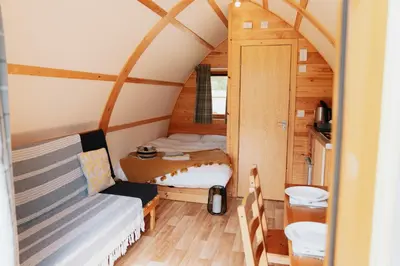 a small bedroom with a bed and a small bathroom at Maglia Rosso by Wigwam Holidays in Bury Saint Edmunds