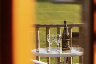 a bottle of wine and two glasses on a table at Maglia Rosso by Wigwam Holidays in Bury Saint Edmunds