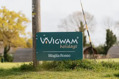 a sign for a wijkun holidays on a pole at Maglia Rosso by Wigwam Holidays in Bury Saint Edmunds