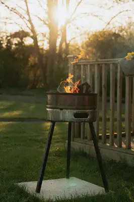 a grill with a fire in the grass at Maglia Rosso by Wigwam Holidays in Bury Saint Edmunds