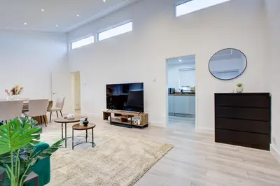 a living room with a television and a dining room at Sleek 3 Bedroom Home Sleeps 6 with Parking in Colchester