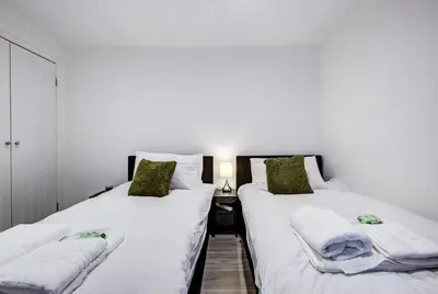 two beds sitting next to each other in a room at Sleek 3 Bedroom Home Sleeps 6 with Parking in Colchester