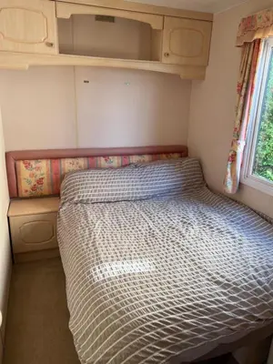 a bed in a small room with a window at The static, it is what it is! in Wicken