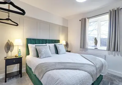 a bedroom with a large bed and a window at Well-Located 4 Bed Property in Colchester, Suited for Families and Business Travelers in Colchester