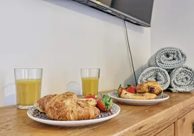 two plates of food on a table with two glasses of orange juice at Well-Located 4 Bed Property in Colchester, Suited for Families and Business Travelers in Colchester