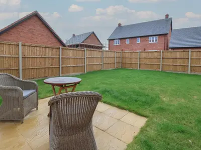 a backyard with a fence and a table and chairs at Inishnee House in Ipswich