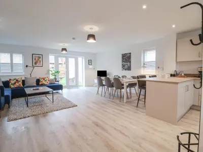 a living room and kitchen with a couch and a table at Inishnee House in Ipswich
