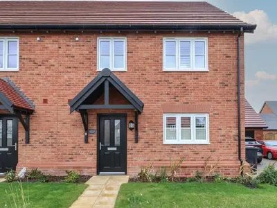 a red brick house with a black door at Inishnee House in Ipswich