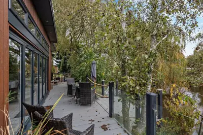 a patio with chairs and an umbrella and trees at 2 Bed in Welney oc-k30123 in Welney