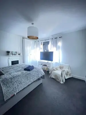 a bedroom with a bed and a desk in it at Artsy Minimalist Suite in Southend-on-Sea