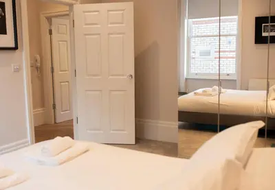 a room with two beds and a mirror at Modern 1Bed Apartment supercentral in Cambridge