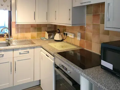 a kitchen with white cabinets and a black stove top oven at Pheasant in Welney
