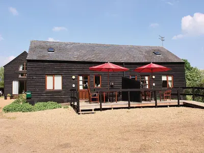 a house with tables and umbrellas in front of it at Swan in Welney