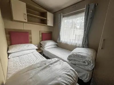 two beds in a small room with a window at Marie Helene, 58 Mallard Carlton Meres Holiday Park in Kelsale