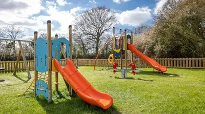 a park with a playground with a slide at Marie Helene, 58 Mallard Carlton Meres Holiday Park in Kelsale
