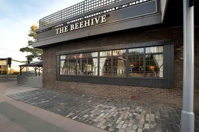 a brick building with a sign that reads the beehive at Serenity-ESE Entire Home in Basildon