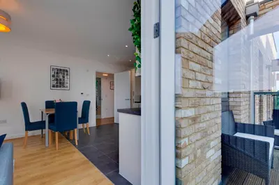 a kitchen and dining room with a brick wall at 54 Woodpecker Way · Modern apartment near Addenbrookes Free parking Pass the Keys in Cambridge