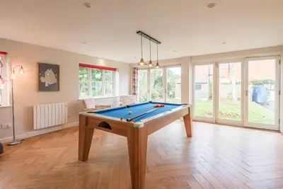 a living room with a pool table in it at Buoys Cottage, Orford in Orford
